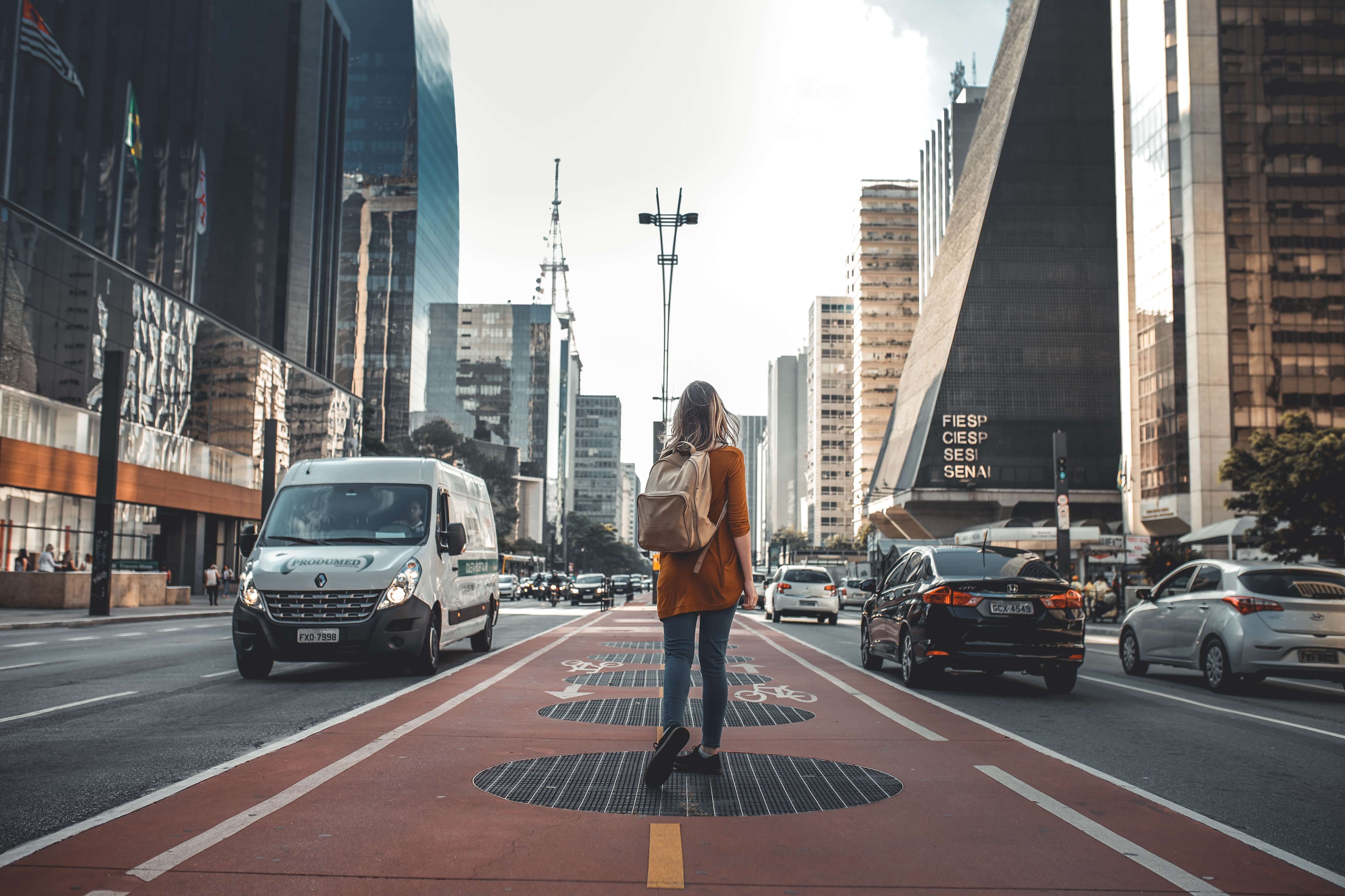 道路の真ん中に立つ女性の後ろ姿