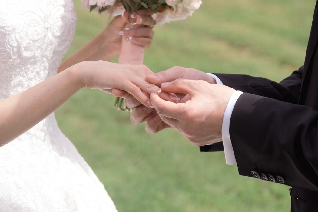 新婦に指輪をはめる新郎