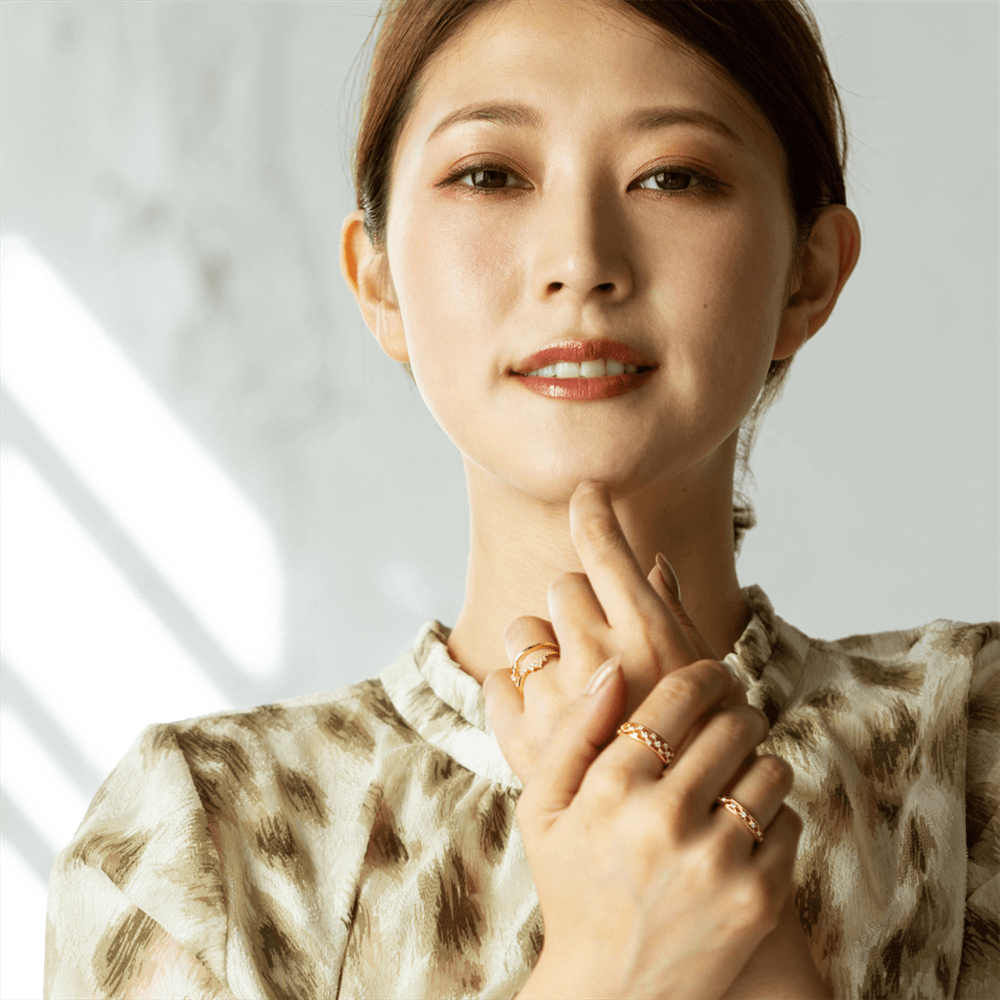 動きと立体感のあるデザインの指輪をした女性