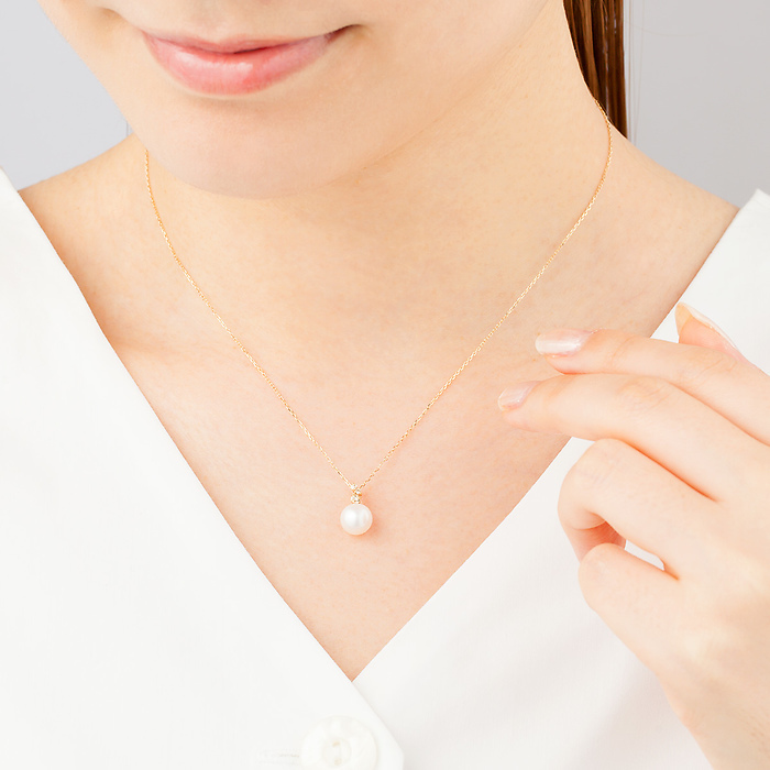 4℃のパールネックレスを身に着ける女性