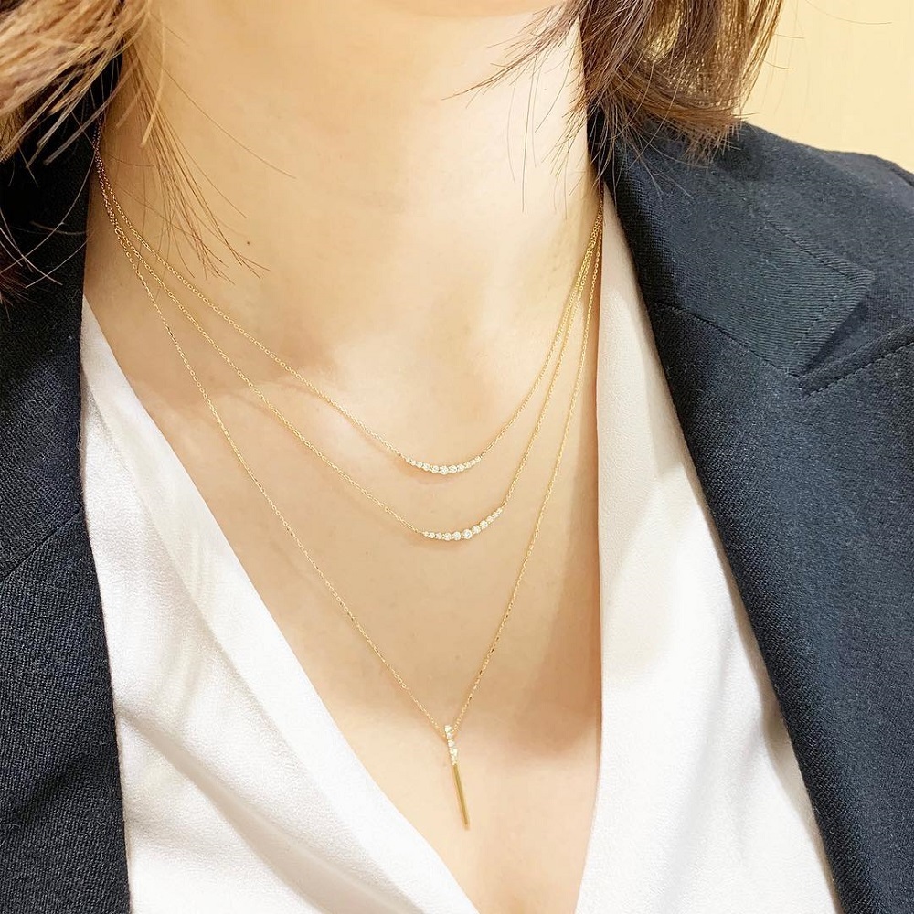 4℃のネックレスを重ね着けする女性