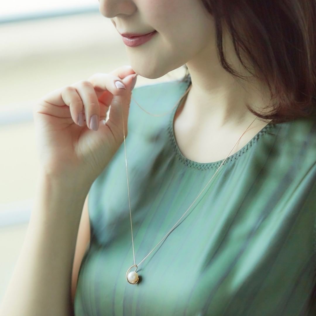 4℃のロングネックレスをつけた女性