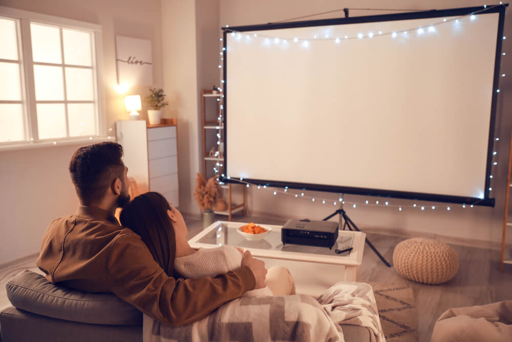 部屋で映画を見るカップル
