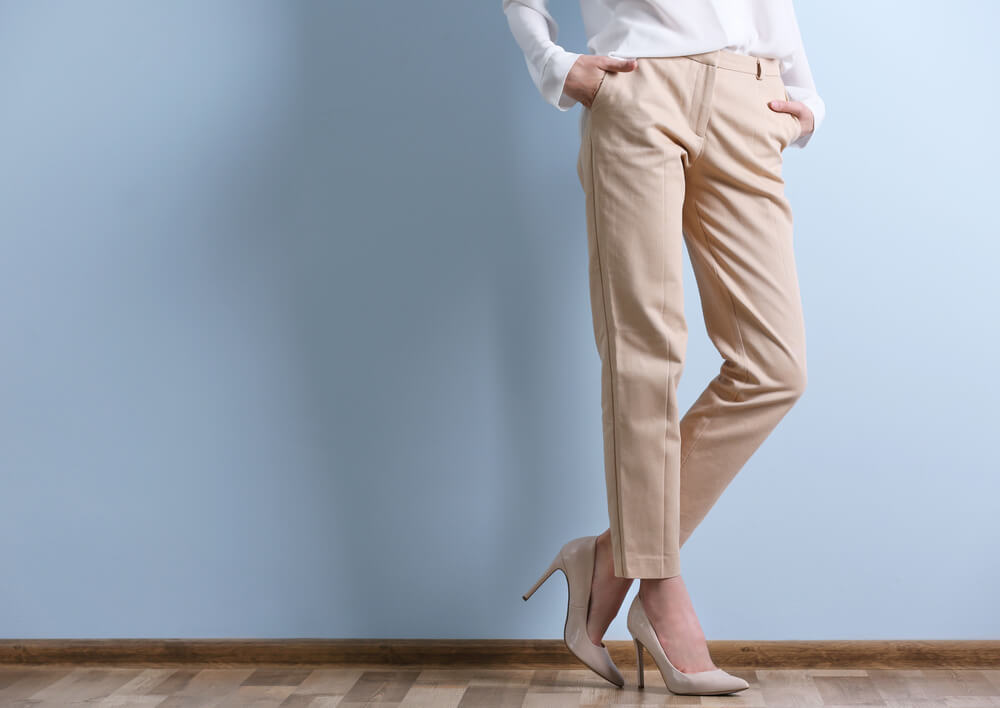 ベージュのテーパードパンツをはいた女性